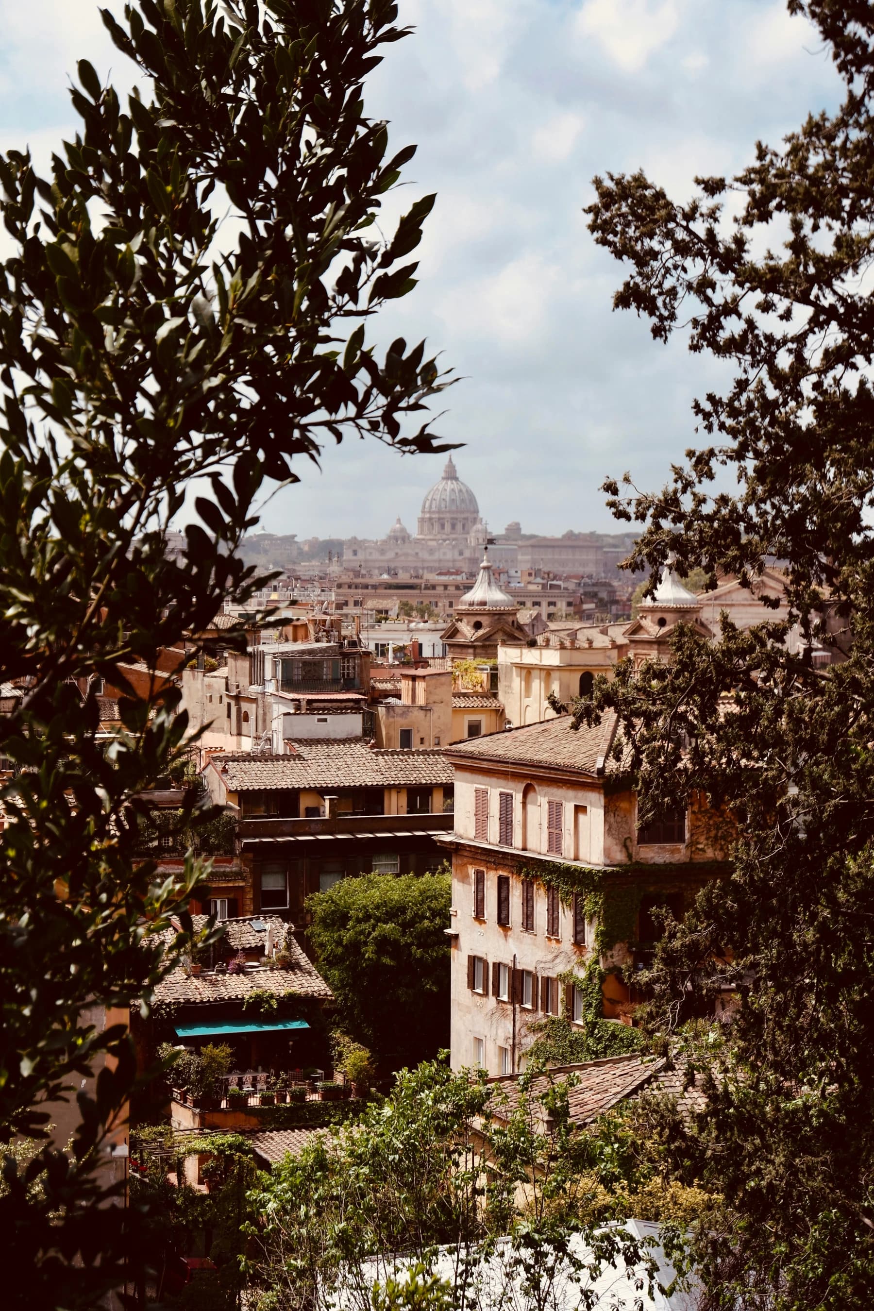 Hazy, overcast rooftops with St Peter's dome in the distance