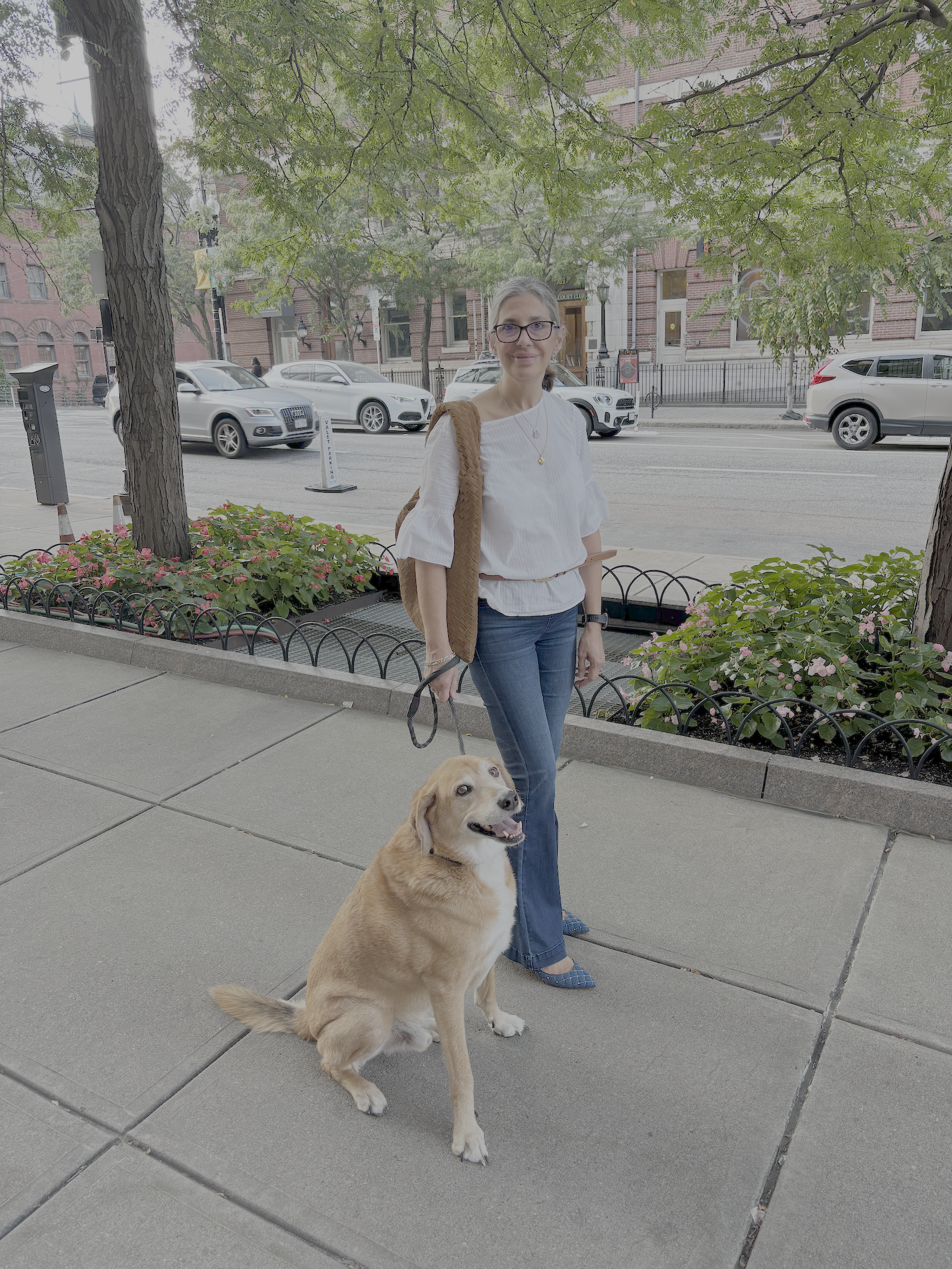 Jojo and her dog Shek on a city sidewalk